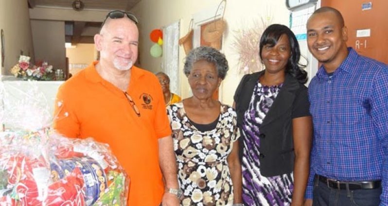 Byer’s Home for Senior Citizens’ representative Pamela Leitch and others receives a hamper from Deputy PS, Human Services Ministry Patrick Findlay
