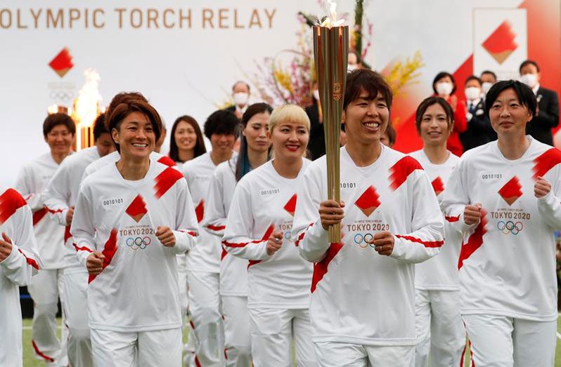 Tokyo 2020 Olympic Torch Relay Grand Start torchbearer Nadeshiko Japan, Japan's women's national soccer team, leads the torch relay in Naraha, Fukushima prefecture, Japan March 25, 2021. REUTERS/Kim Kyung-Hoon/Pool.