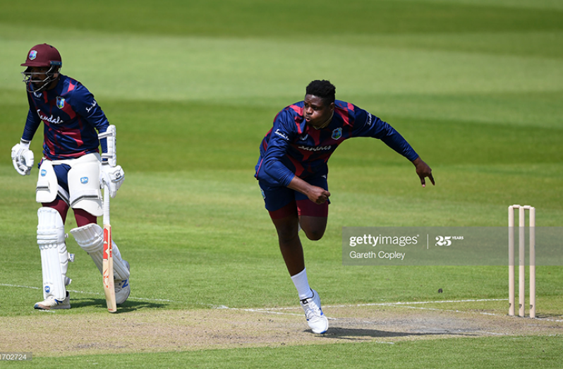 Oshane Thomas bowls as Sunil Ambris watches on during Day Two of a West Indies warm-up match at Old Trafford on June 24, 2020 in Manchester, England. (Photo by Gareth Copley/Getty Images for ECB)