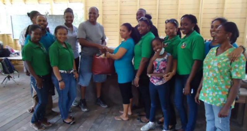 Rotarian Jeffrey Layne hands over the donation to Headmistress Josephine Ashby in the presence of others