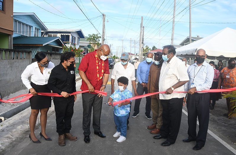 Four-year-old Zackariyya Khan cut the symbolic ribbon to commission the recently-rehabilitated Owen Street. Also pictured are his parents, Minister of Public Works, Bishop Juan Edghill, and officials of the Public Works Ministry (Adrian Narine photo)