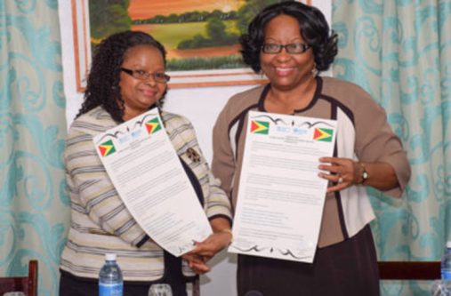 Minister of Public Health, Volda Lawrence, and Pan American Health Organisation/World Health organisation Director, Dr Carissa Etienne, exchange the signed Country Cooperation Strategy (CCS) 2016-2020