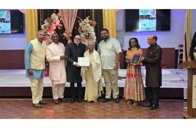 Pandit Virjanand Joe Jaglall receives his award from a member of the Arya Samaj