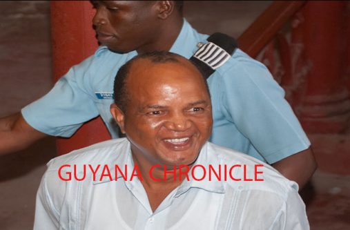 REO of Region 9 Carl Parker smiles as he is escorted out of the Georgetown Magistrate's Court.