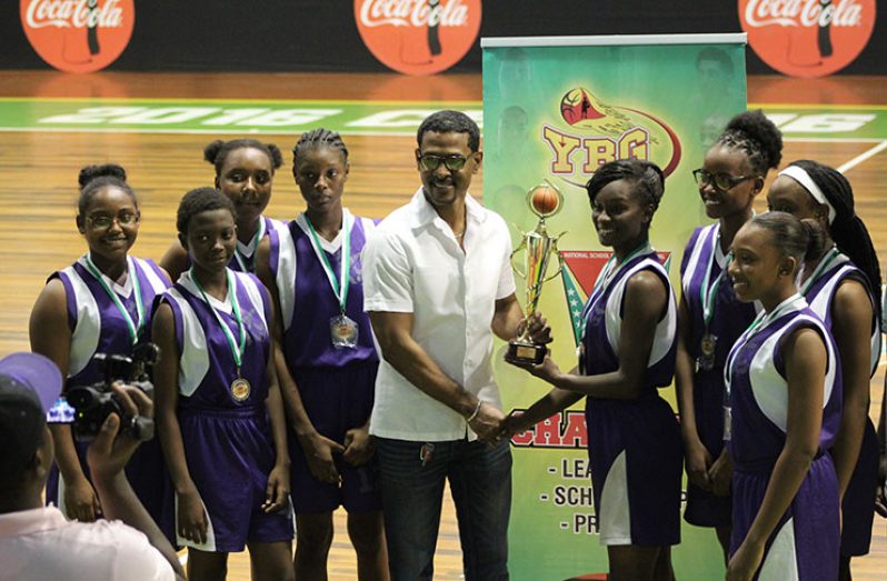 President's College team captain and MVP, Annalisa Barclay, collects the women’s winning trophy from YBG Director Rayad Boyce.