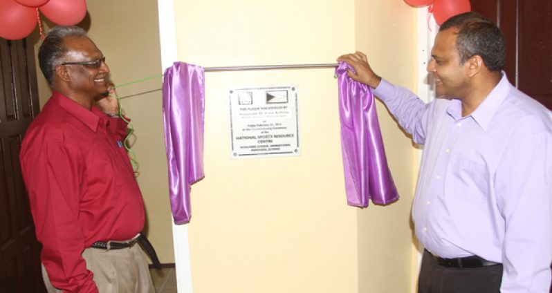Minister of Sport Dr Frank Anthony (right), and Director of Sport Neil Kumar unveil the plaque at the newly opened National Sports Resource Centre.