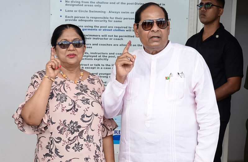 Prime Minister Moses Nagamootoo and his wife Mrs. Sita Nagamootoo displaying their index fingers shortly after voting at the National Aquatic Center (Delano Williams photo)