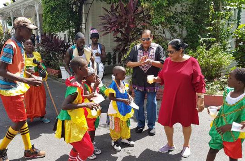 Prime Minister Moses Nagamootoo and wife Sita Nagamootoo give the young masqueraders a treat (DPI photo)