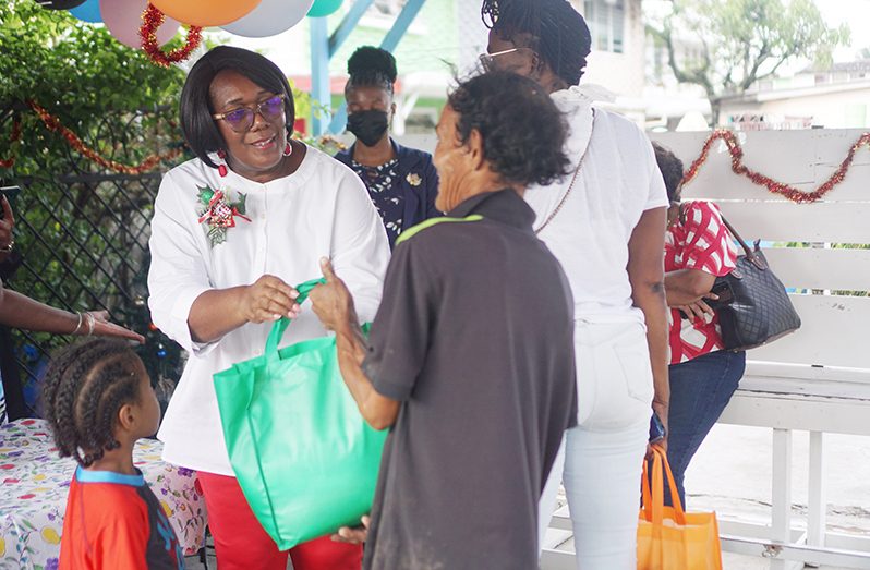 Prime Minister’s wife, Mignon Bowen-Phillips (left) shares a food hamper to a smiling resident (Elvin Croker photo)
