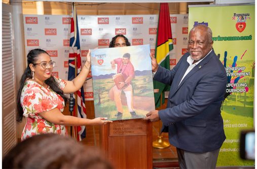 Prime Minister, Brigadier (Ret’d) Mark Phillips, receives a vibrant painting symbolising the spirit of the Rupununi Music and Arts Festival during the fundraising auction