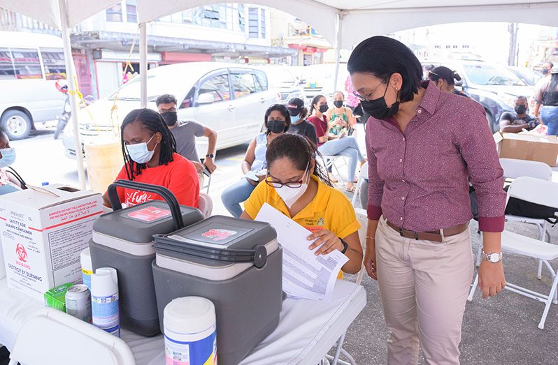 Minister within the Ministry of Housing, Susan Rodrigues, engages Health Ministry staff at the PPP/C’s vaccination drive and barbecue