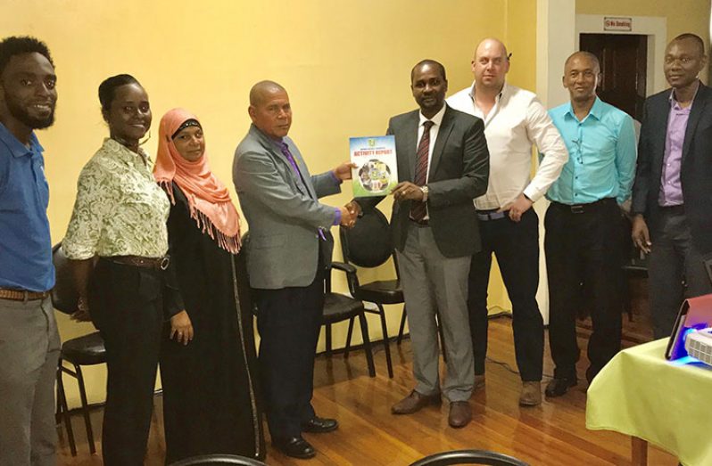 President Wayne Forde presents GFF's 2017 Activity Report to Minister Norton in the presence of GFF and Ministry officials.