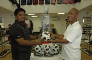 Managing Director of Chetsons,, Inshaan Ramkellawan, (left) hands over one of the balls to Three Peat Promotions’ Rawle Welch on Thursday, at the entity’s location.