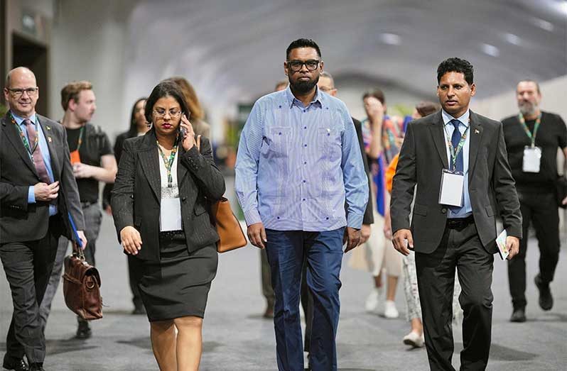President Dr. Irfaan Ali (centre) is flanked by Pradeepa Bholanath, Environmental Economist and Shyam Nokta, natural resources, environment and climate change consultant in Belém, Brazil (Office of the President photo)