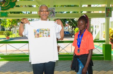 CARIFTA Games Gold Medallist (U-18 3000M) Claudrice McKoy, presenting President Granger with a T-Shirt of Team Guyana’s participation at the event (Delano Williams photo).