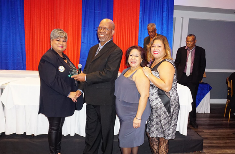 OSCL secretary/PRO Frederick Halley receives the Norman Sue Spirit Award from Kim Sue, daughter of the late Norman Sue. Also in picture are sisters Natasha and Nashenka.