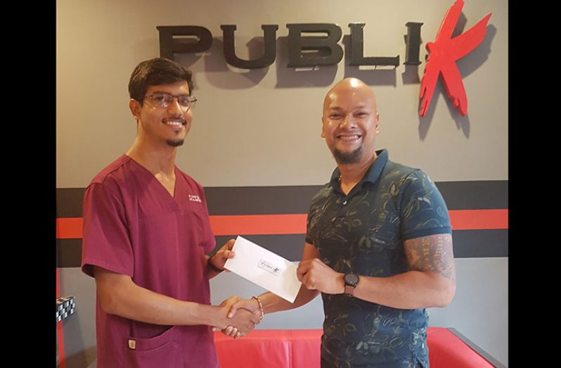 SCSA Chairman, Dr. Pravesh Harry (left) receives sponsorship from Sean Major, founder of The Publik Wing and Burger House.