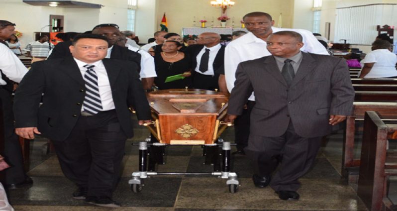 The coffin of former GCB statistician Ron Legall is lifted out of Our Lady of Fatima Roman Catholic Church by cricket stakeholder Bissondyal Singh, Georgetown Cricket Association president Roger Harper and workmates.