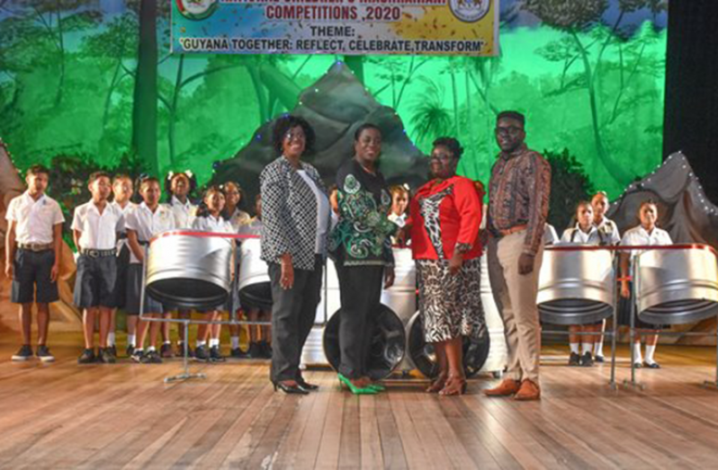 Minister of Education, Dr. Nicolette Henry (second left) and Unit of Allied Arts Administrator, Lorraine Barker-King (first left) make the presentation to representatives of Mahdia Secondary School (right) and the students (DPI photo)