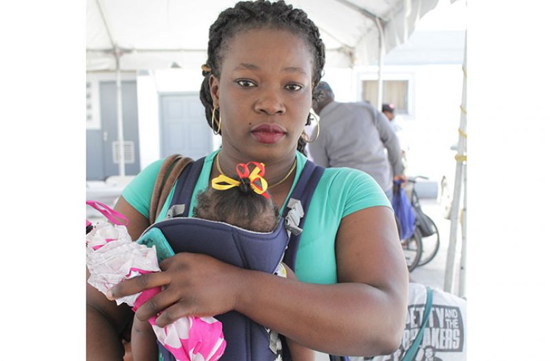 Ephah McKenzie holds her baby, Josiah McKenzie, as she visited the Ministry of Public Health (MoPH)’s Public Day on Friday last [Vishani Ragobeer photo]