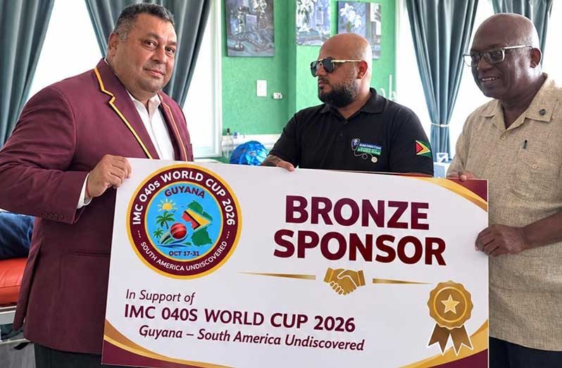 Photo shows Raj Singh congratulating Satyendra Khemraj aka Samba, owner of the New Doctors clinic in the presence of Paul Archer, World Cup transportation coordinator
