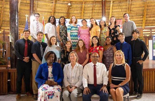 Seated from right: U.S. Ambassador to Guyana, Nicole Theriot, and Minister of Health, Dr. Frank Anthony, along with other officials flanked by the 35th Cohort of Peace Corps Guyana Volunteers sworn in at the Umana Yana in Kingston, Georgetown