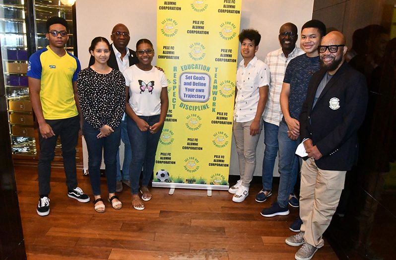Pele FC Alumni Corporation Executive Committee Members, Patrick ‘Labba’ Barton (right), Eric ‘Riggy’ Smith (3rd right) and Denis Carrington (3rd left) pose with the Scholarship Students on Friday at the Marriott Hotel, Kingston, Georgetown.