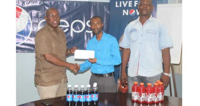 GBA president Steve Ninvalle receives the sponsor’s cheque from Pepsi brand manager Larry Wills while GBA technical adviser looks on (Sonell Nelson photo)