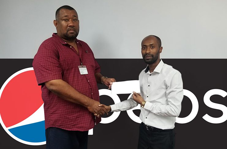 DDL Marketing Executive Larry Wills (right) hands over sponsorship to RHTYSC Secretary/CEO Hilbert Foster.