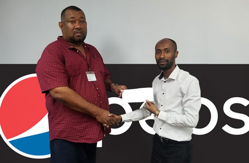 DDL Marketing Executive Larry Wills (right) hands over sponsorship to RHTYSC Secretary/CEO Hilbert Foster.