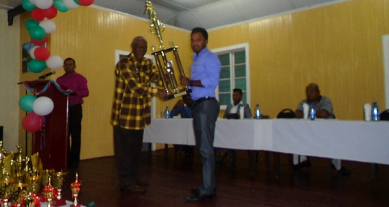 Cricketer-of-the-Year, Veerasammy Permaul receives his award from Gervy Harry, Administrative Officer NSC.
