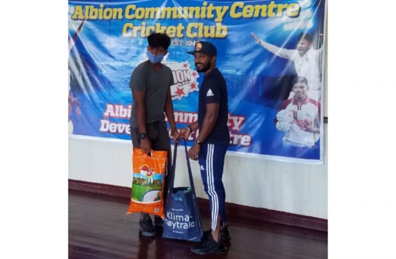 Guyana and West Indies cricket Verasammy Permaul (with cap) presents a food hamper to one of the club’s young cricketers.