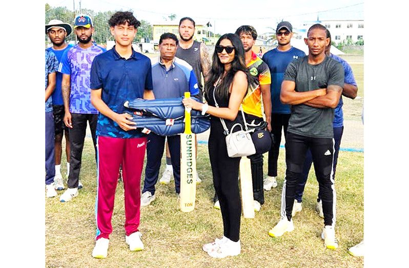 Revali Perreira (left) is presented with cricket gear by Natali Nagamootoo on behalf of her uncle Vishal Nagamootoo.