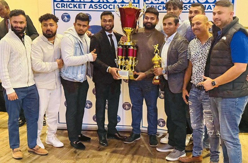 SCA President Shiv Persaud presents the winning Elite League trophy to Victoria Park skipper Sailesh Patel in the presence of other teammates