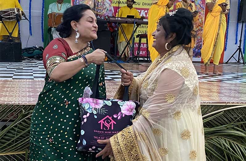 President of the Guyana Hindu Dharmic Sabha, Dr Vindya Persaud, hands over a hamper