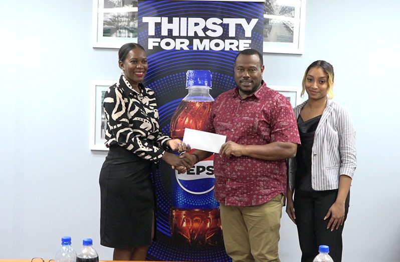 Brands communication manager of DDL Schemel Patrick handing over the sponsorship Cheque to Petra’s Troy Mendonca Alleah Hamid sharing the moment