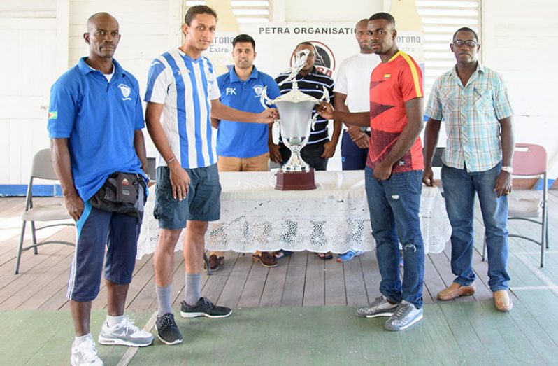 GFC representatives (left) and their Police opponents pose with the Corona Invitational Trophy. Only one winner will emerge on Sunday evening. (Samuel Maughn photo)