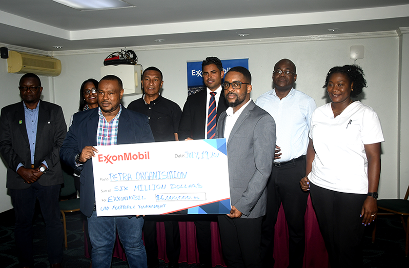 Petra Organisation co-Director Troy Mendonca (left) collects the $6M sponsorship from CRA at ExxonMoblil, Ryan Hoppie. In the background (L-R) are GFF TDO Bryan Jopseh, Assistant Director of Sport Melissa Dow-Richardson, NSC Chairman Kashif Muhammad, Minister of Sport Charles Ramson, Education Adviser Olato Sam and Petra’s Jacquline Boodie (Adrian Narine photo)