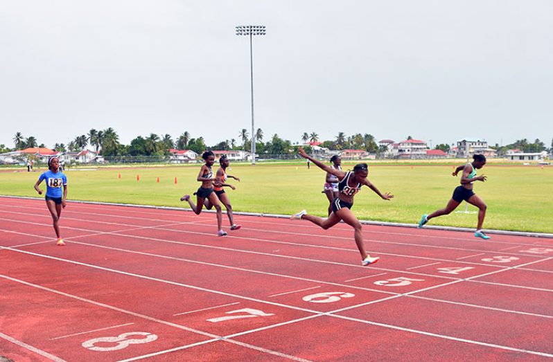 Toyan Raymond (black) pips Kenisha Phillips (right) on the finish line in the Girls U-20 100M. (Samuel Maughn Photo)