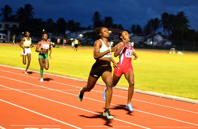 Kenisha Phillips eases across the finish line ahead of Alita Moore (right) to capture the Women’s 200m and the sprint double at the AAG’s National Senior Championships (Adrian Narine photo)