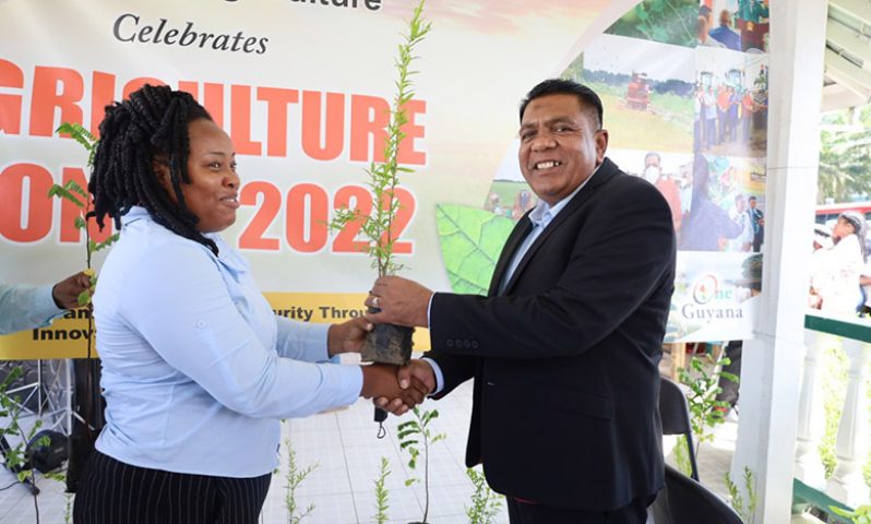 Agriculture Minister Zulfikar Mustapha hands over a seedling to a member of the public (Adrian Narine photo)