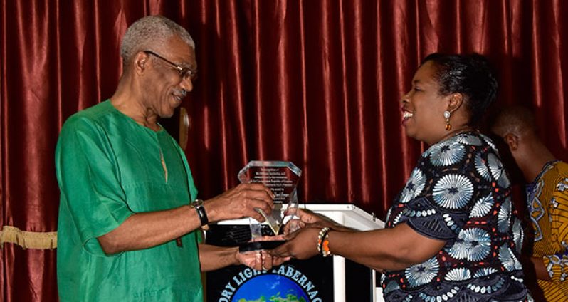 The President receives a token of appreciation from Pastor Jacqueline Yorrick of the Glory Light Tabernacle church