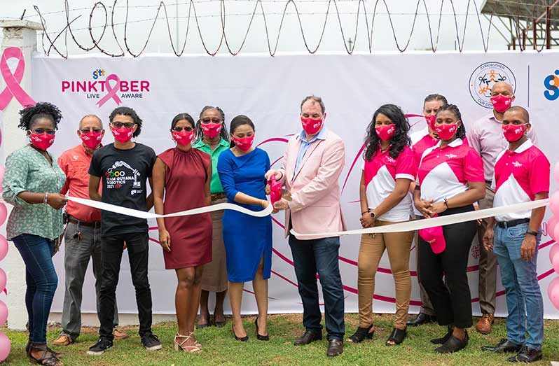 GTT’s CEO, Damian Blackburn, cuts ribbon at the “Wall of Hope” in the National Park to officially launch Pinktober 2021. In photo are members of the GTT Senior Management team, sponsors and Pinktober partners (GTT photo)