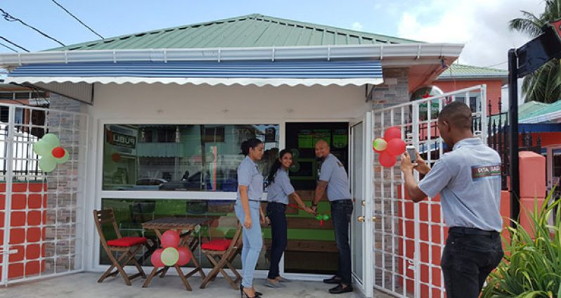 Pita Bar owner Sean Major cuts the ribbon to officially open the business on Friday. His wife Shavana Persaud and General Manager Rehana Rambarran look on