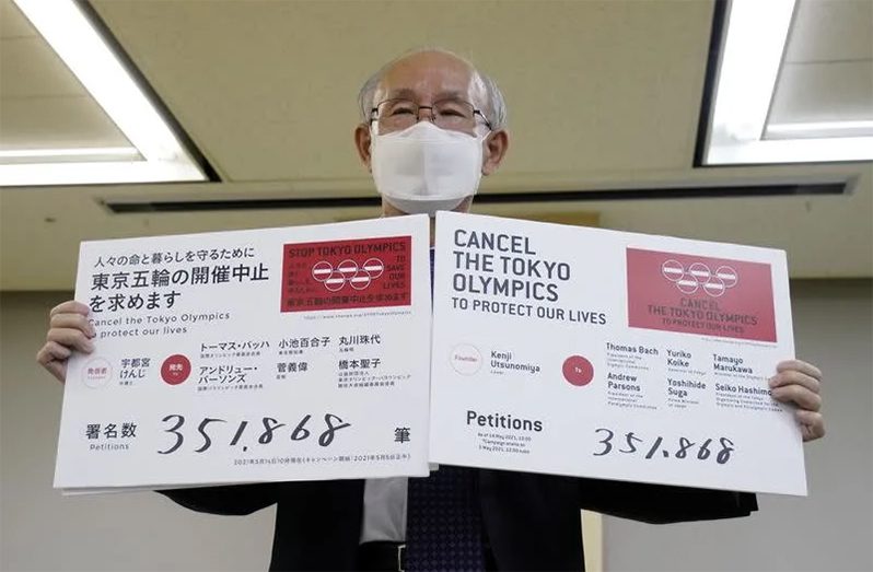 Lawyer Kenji Utsunomiya shows off placards during a news conference after he and anti-Olympics petition organiser submitted a petition calling for the Tokyo 2020 Olympics to be cancelled in Tokyo.