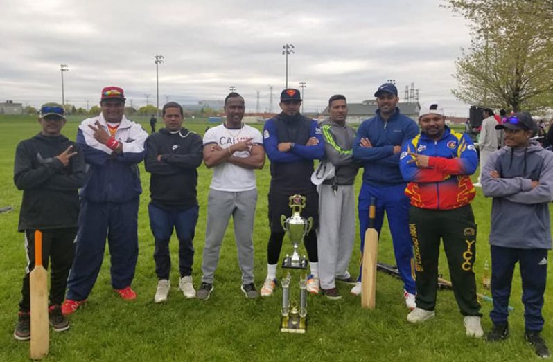 Members of Assassins pose with the winners’ trophy following their victory.