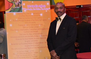 James Richmond standing next to an enlarged copy of his poem the Golden Jubilee
