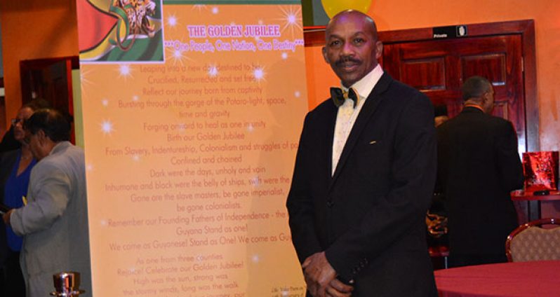 James Richmond standing next to an enlarged copy of his poem the Golden Jubilee