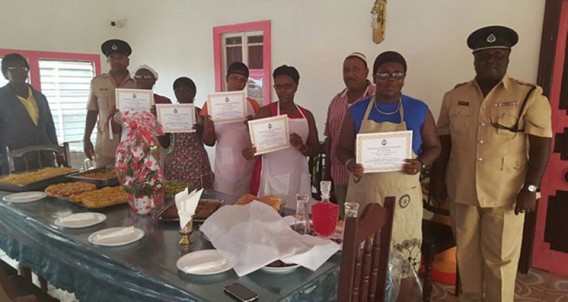 Commander Stephen Mansell with senior officers posing with the graduates of the food and nutrition course at Madina Restaurant