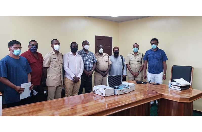 From right: Region Three Chamber of Commerce President, Halim Khan; Deputy Commander, Boodnarine Persaud; head of GIT, Sheik Aleem, and Commander Errol Watts, along with other ranks and officials of the chamber pose next to the environmental noise-measurement kits